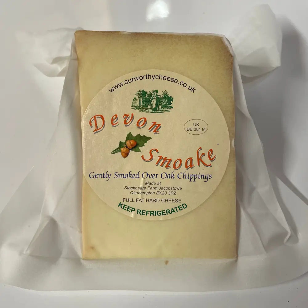 A rectangular block of pale yellow curworthy cheese devon smoake wrapped in clear plastic features natural oak flavor