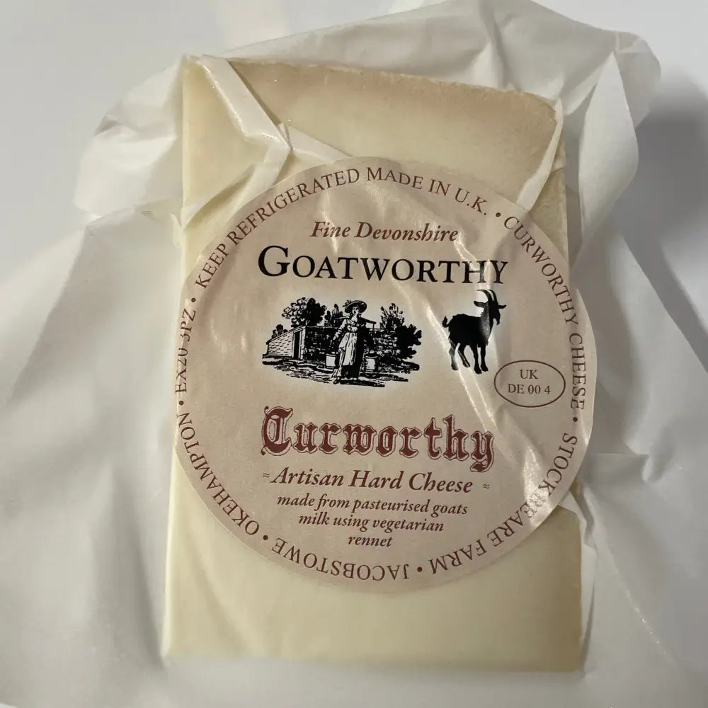 A round pale yellow curworthy cheese goatworthy hard cheese wheel wrapped in clear plastic with a cream label