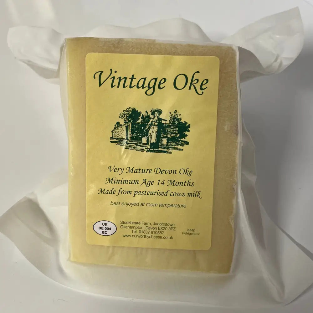 A block of curworthy cheese vintage oak mature devon cheese wrapped in clear plastic with yellow label and black text