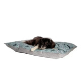 A soft light blue deep duvet dog bed with dark green dinosaur prints and striped sides from danish design battersea playful dogs
