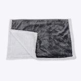 A plush gray and white sherpa fur blanket from danish design essentials with a soft textured surface perfect for cozy use