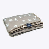 A soft gray danish design essentials polar fleece blanket with white paw prints and a neat stitched edge