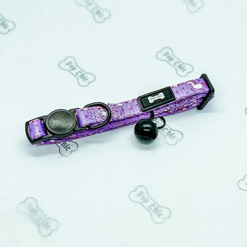Purple patterned unicorns cat collar with black quick release hardware and a small black bell for cats
