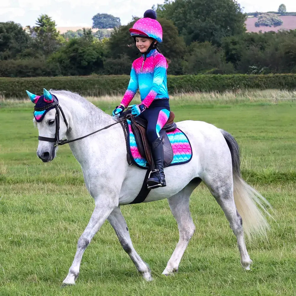 A white horse wearing the dazzling diamond fly veil by little rider with a vibrant pink blue gradient and quality close-knit crochet