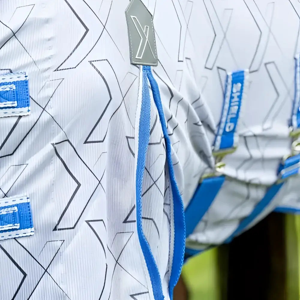 Defencex shield quagga fly rug with white shirt, black geometric pattern, blue straps, and shielding patterned micromesh