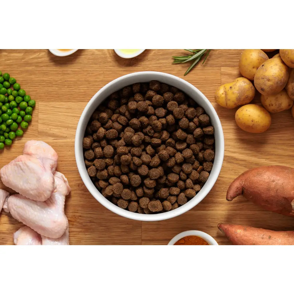 Brown kibble of john grain free chicken dog food in a white bowl showing grain free chicken dog nutrition