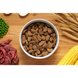 A white ceramic bowl filled with brown john silver beef dog kibble for silver beef dog food with vegetables