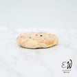 A golden-brown east & west eccles cake shortbread cookie with dark chocolate chips, not round white bread style