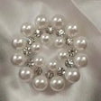 A circular cluster of white pearls and clear rhinestones in an elegant pattern on equetech bijou stock pins