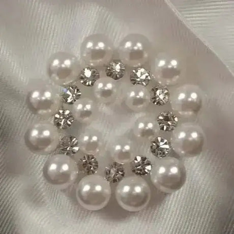 A circular cluster of white pearls and clear rhinestones in an elegant pattern on equetech bijou stock pins