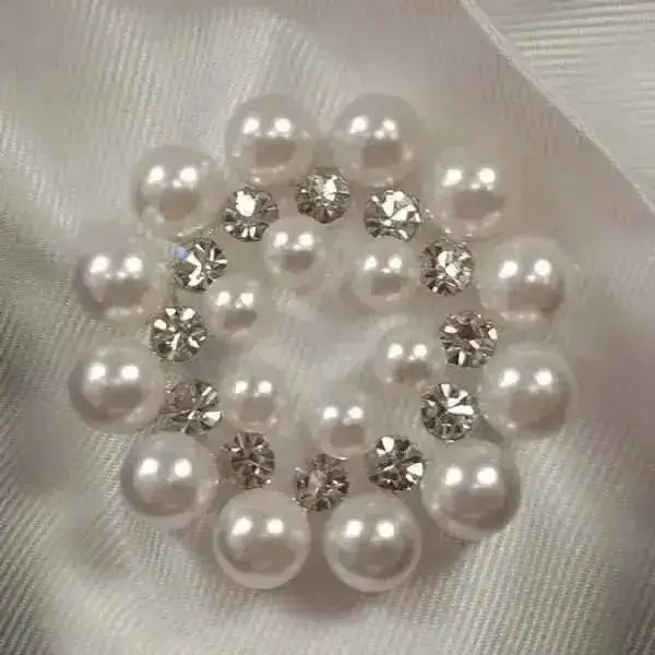 A circular cluster of white pearls and clear rhinestones in an elegant pattern on equetech bijou stock pins