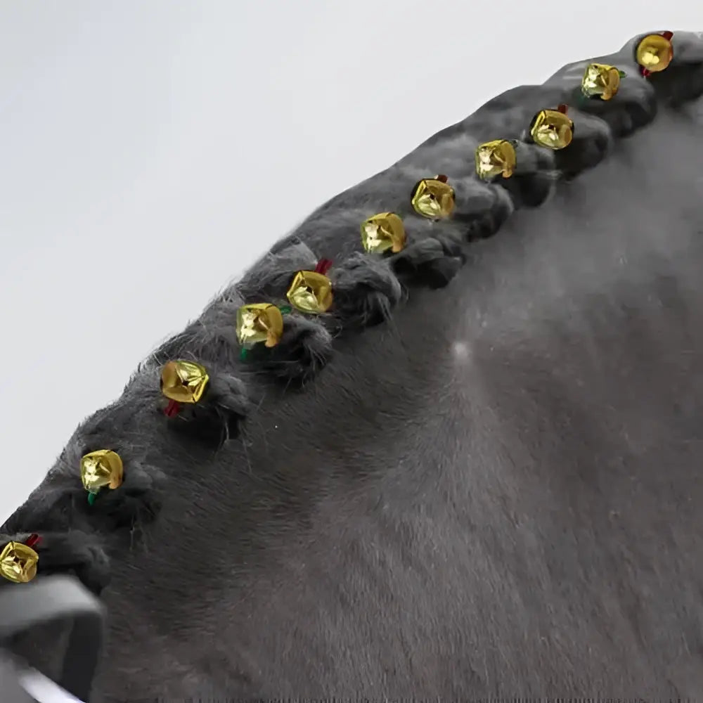 A row of small shiny gold bells on dark gray braided mane using equetech christmas plaiting bands