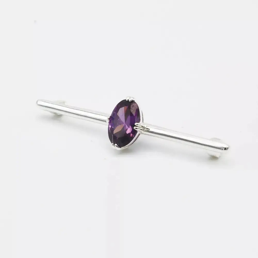 A sleek silver equetech deluxe amethyst stock pin with a central oval-cut purple amethyst stone