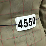 White plastic jacket competition numbers with black digits attached by velcro to plaid equetech easy show jacket