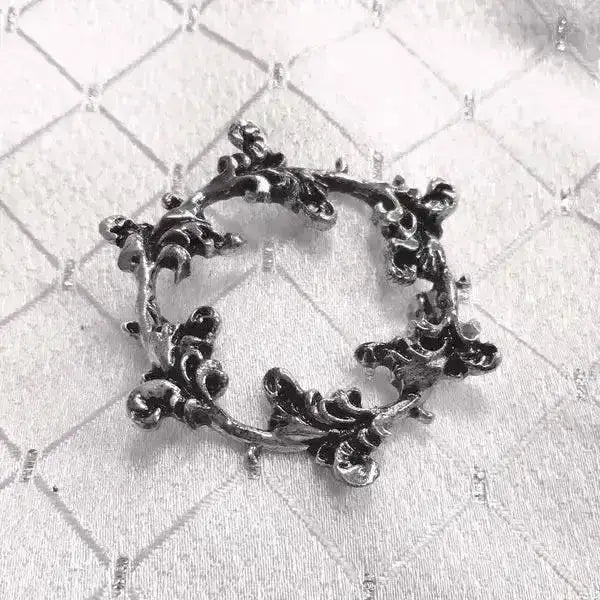 Ornate black metal stock pin floral shaped like circular wreath of intricate leafy vines equetech floret silver plated