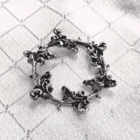 Ornate black metal stock pin floral shaped like circular wreath of intricate leafy vines equetech floret silver plated