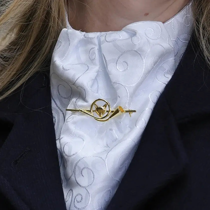 Gold-colored equetech french horn fox stock pin with a stylized fox and intricate swirling patterns on its body