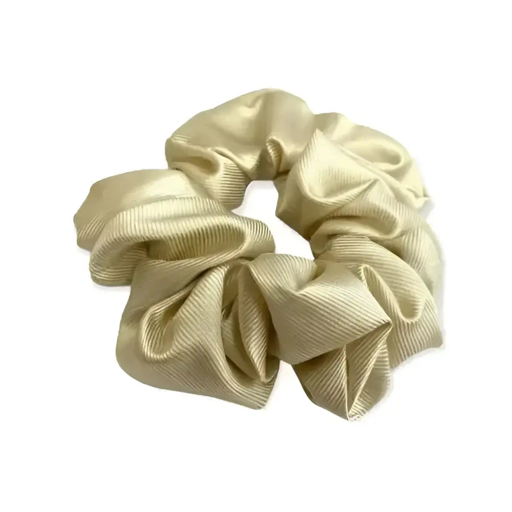 A shiny gold satin equetech hair scrunchie with a soft gathered texture and subtle ribbed detail jacquard hair accessory