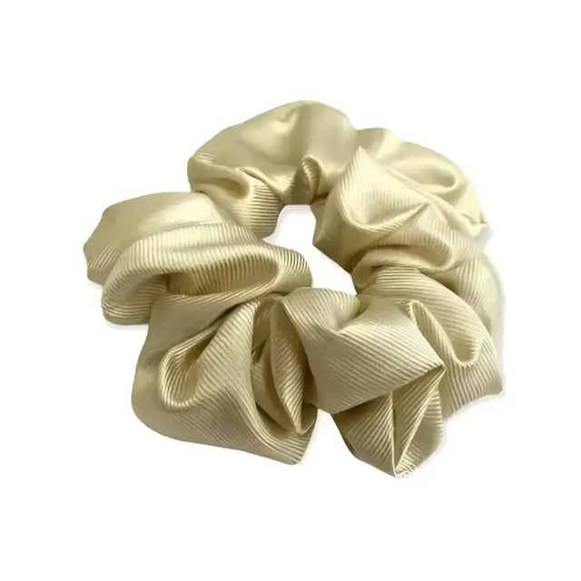 A shiny gold satin equetech hair scrunchie with a soft gathered texture and subtle ribbed detail jacquard hair accessory