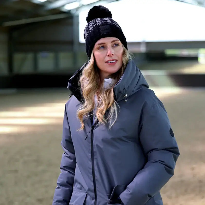 Gray puffer jacket paired with equetech houndstooth waterproof knit hat featuring a black pom pom beanie style
