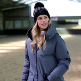 Gray puffer jacket paired with equetech houndstooth waterproof knit hat featuring a black pom pom beanie style