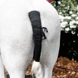 Black textured equi-sential tail bandage wrap with small black strap tied around for secure tail support
