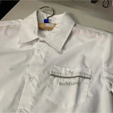 White button-up equi theme competition shirt with chest pocket embroidered with gray equitherm logo