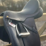 Black leather english saddle with silver stirrups and gold buckle next to equine emergency tag for instantly accessible emergency contact details
