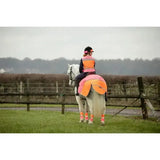 Bright orange equisafety hi-vis waterproof quarter sheet with pink trim worn by rider for safety and visibility