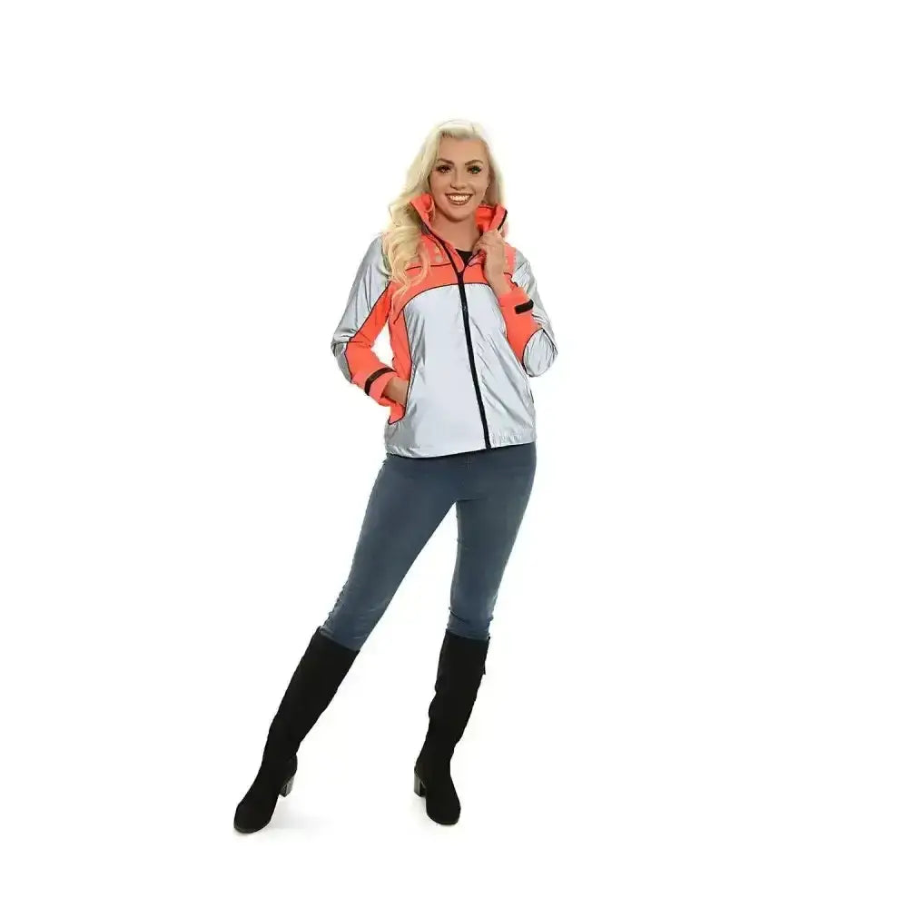 A woman wearing an equisafety mercury lightweight orange and silver reflective riding coat with zip up panels