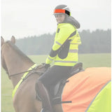 A rider in a yellow high-visibility jacket and helmet with an equisafety multi-coloured hatband on a horse wearing a reflective vest