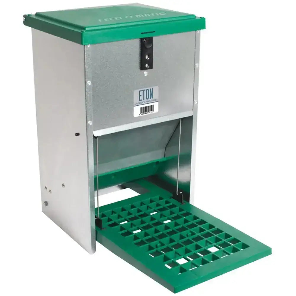 Green and silver metal eton treadle poultry feeder with hinged lid, perforated tray, locking mechanism, and quiet treadle action