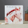 A fanciful dolomite card featuring a white horse with red mane on textured off-white paper, individually cello wrapped with outer gloss varnish