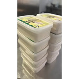 Stacks of white plastic farmer toms ice cream tubs with green and yellow clotted cream vanilla labels