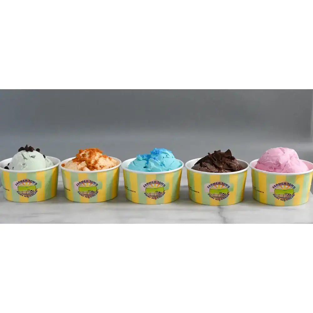 Five colorful farmer toms ice cream small tubs with yellow and green striped design including clotted cream vanilla