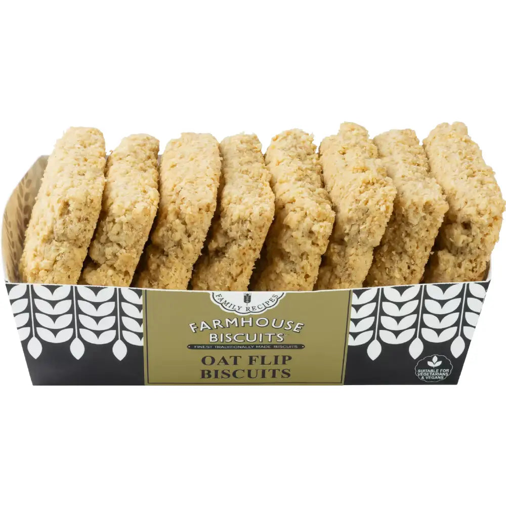 A box of farmhouse biscuits oat flip biscuits with golden brown oat biscuits in a black and white patterned container