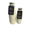 Two glass bottles of farrs farm pasteurised full fat milk with silver caps and black labels tied by blue string