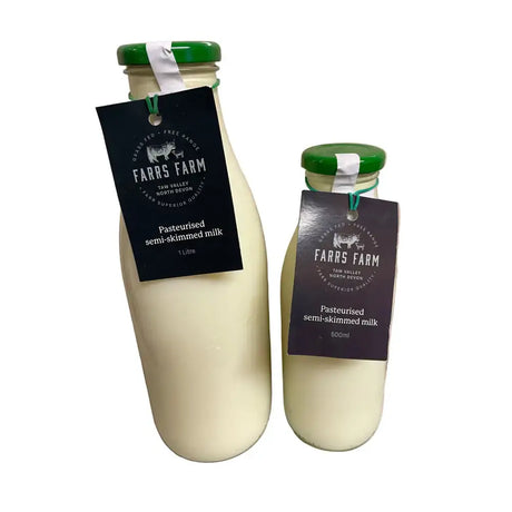 Two glass bottles of farrs farm pasteurised semi skimmed milk with green caps in 1 litre and 500ml sizes
