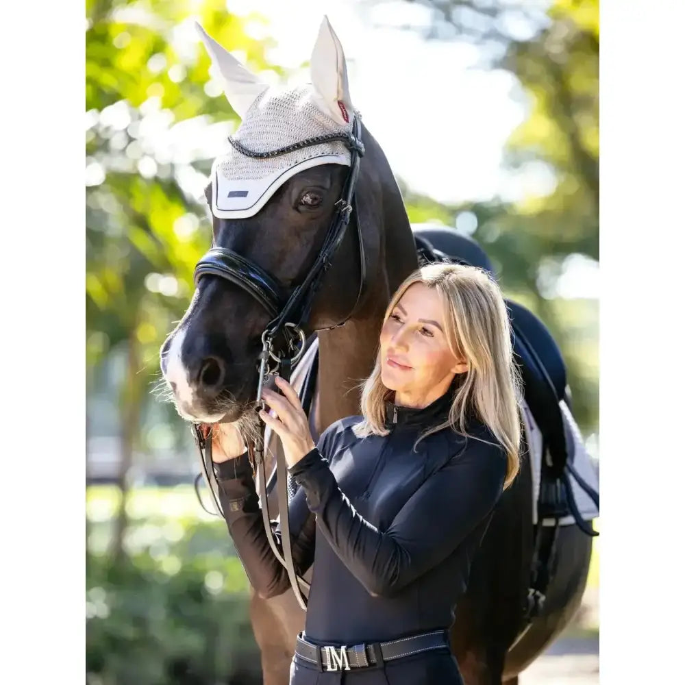 Black horse wearing a white and gray mesh finesse fly hood stone with black leather straps for fly protection