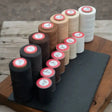 A collection of flat waxed plaiting thread spools in black brown beige and white for smart grooming flat wax use