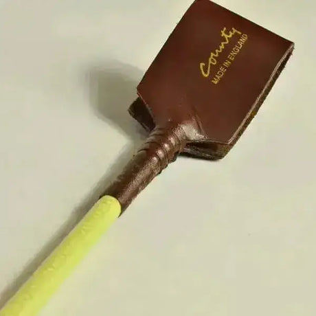 Brown leather flax stem riding crop with yellow handle and gold county made in england lettering super stylish high quality riding whip