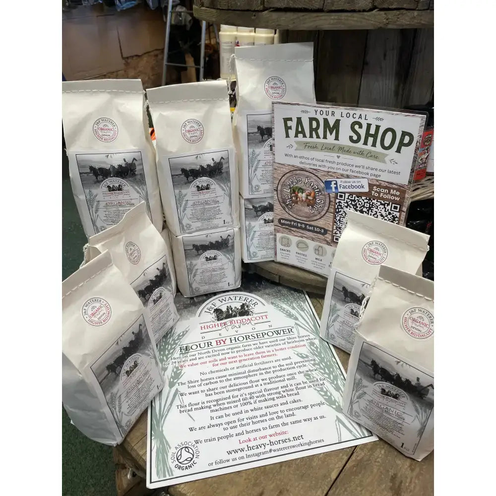 White paper bags of horsepower organic ancient grain stoneground organic flour with black and white horse and cart design