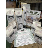 White paper bags of horsepower organic ancient grain stoneground organic flour with black and white horse and cart design