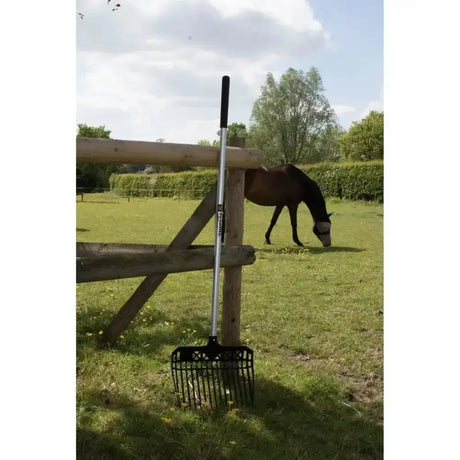 Fynalite value plastic stable fork long handle black and silver with sturdy handle leaning against wooden fence for pellet bedding