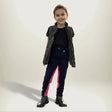 A child wearing gallop children’s two tone jodhpurs with eye catching contrast pink side panels and shiny black boots