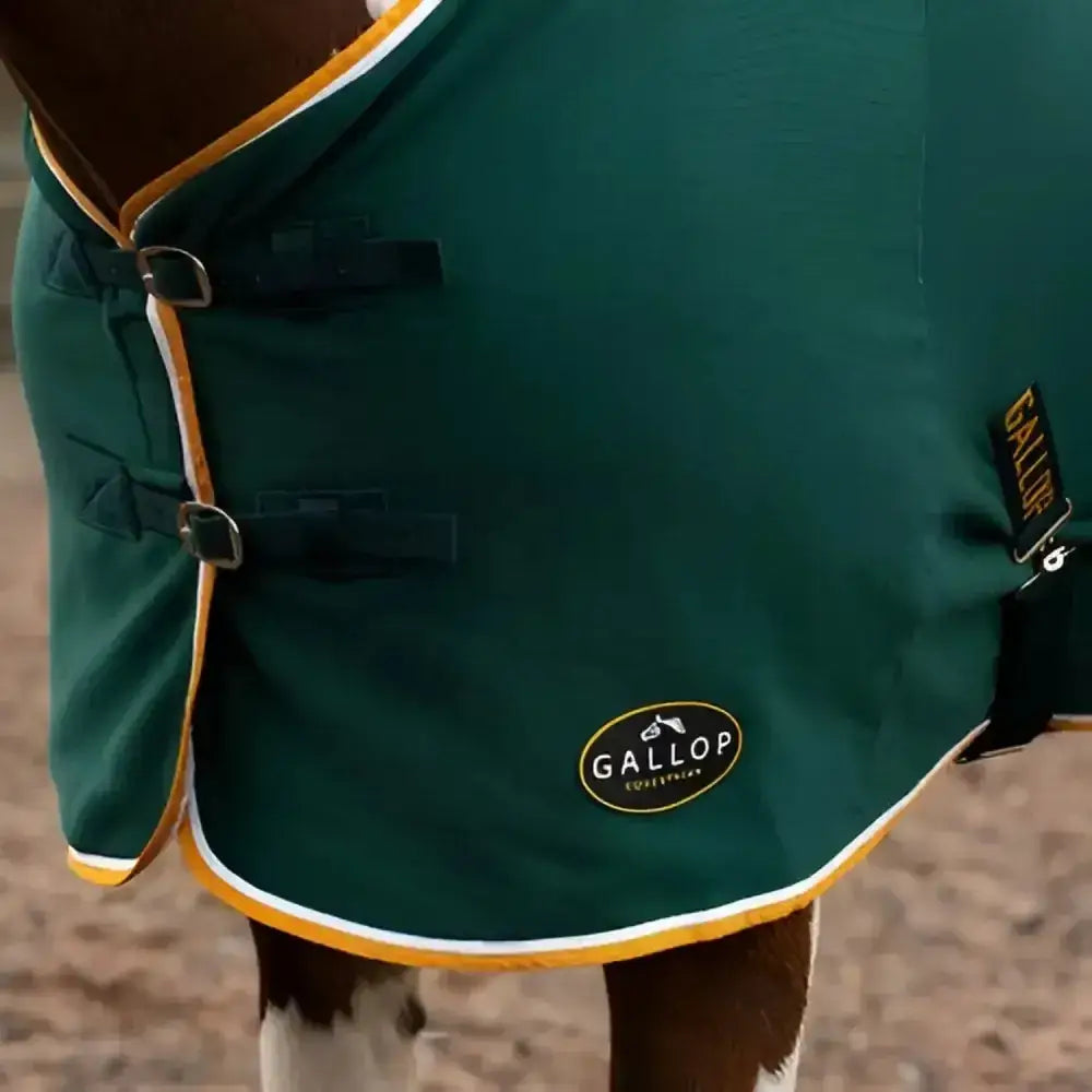 Deep green gallop jersey cooler rug with yellow white trim black buckles and branded oval patch in cooler rug green