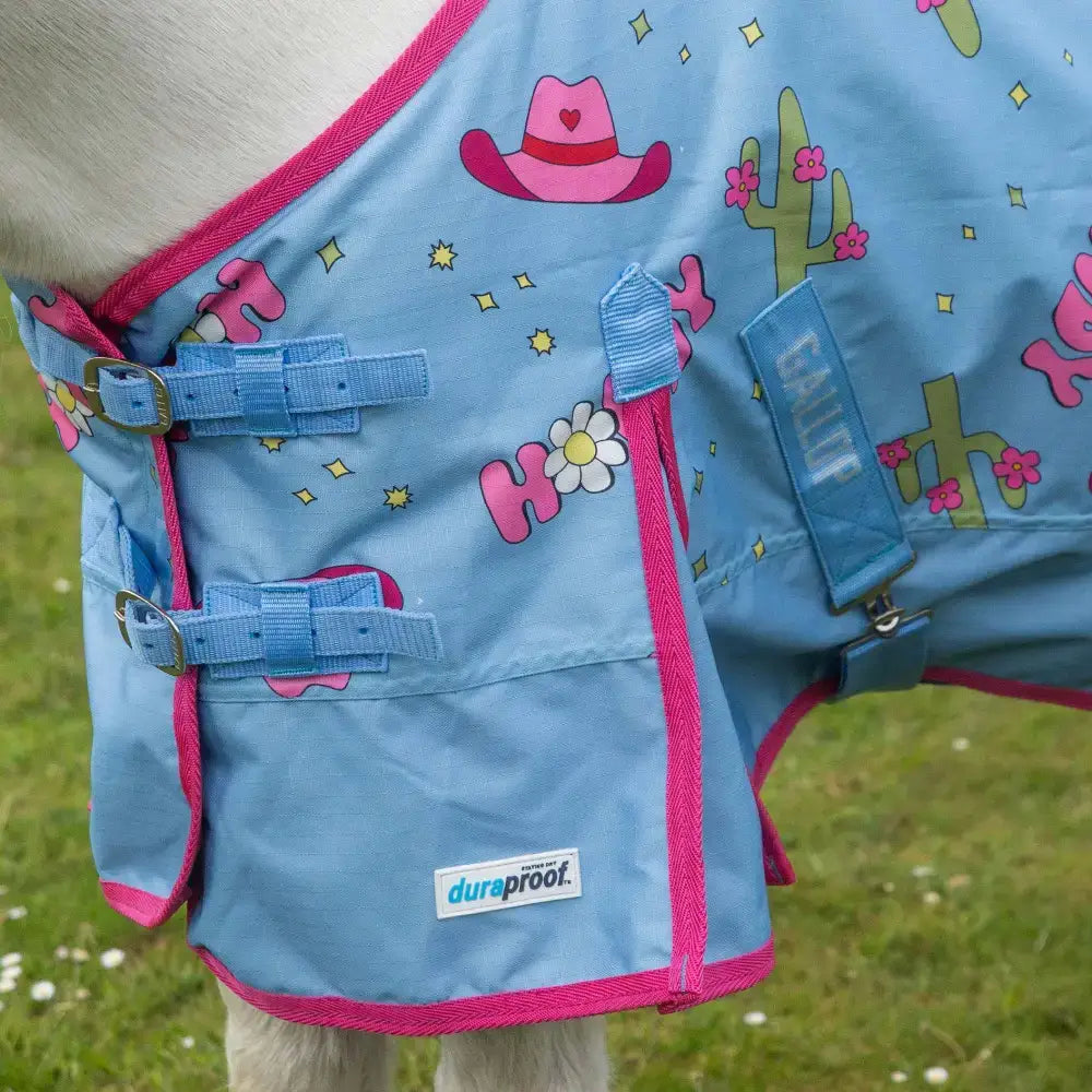 Light blue and pink patterned gallop ponie duraproof turnout rug with howdy partner cartoon cowboy hats and cactuses