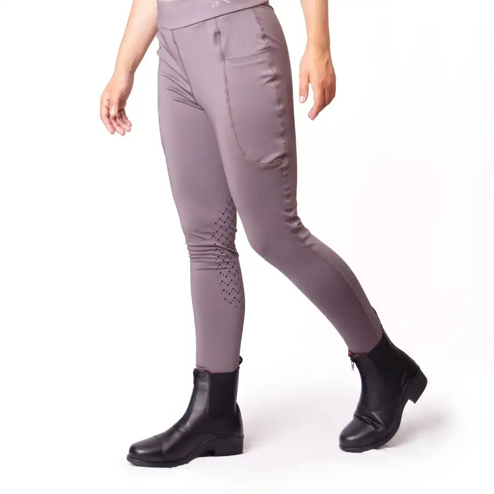 A pair of mauve gallop riding stretchy leggings boast pockets silicone knee and perforated detailing on the thighs