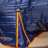 Blue quilted gallop trojan 100g stable rug with orange trim and black tag showing 100g weight and optional neck cover