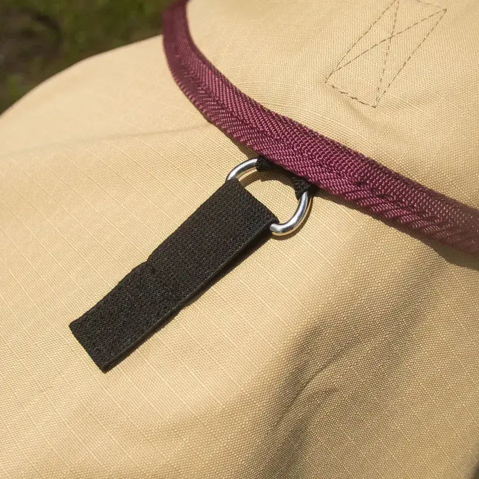 Beige canvas gallop trojan fly hat with burgundy herringbone trim and black velcro strap on silver ring